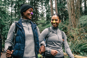 Two friends hiking in nature using Nöz's eco-friendly sunscreen for nose